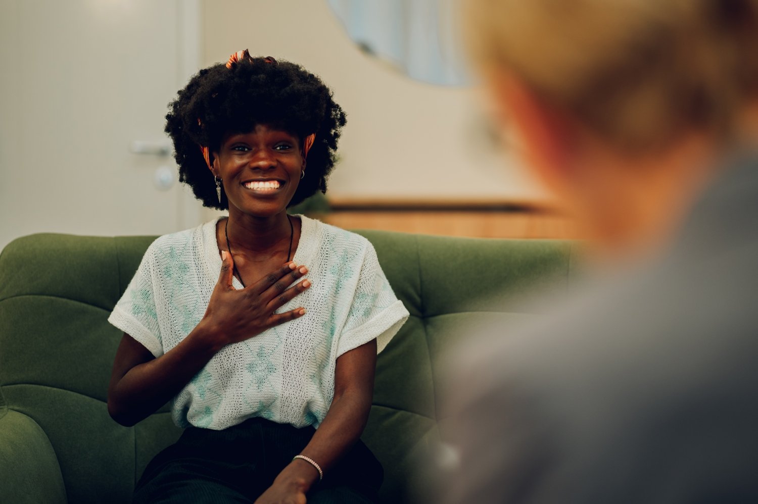 A happy african american woman is sitting at the psychotherapist's office