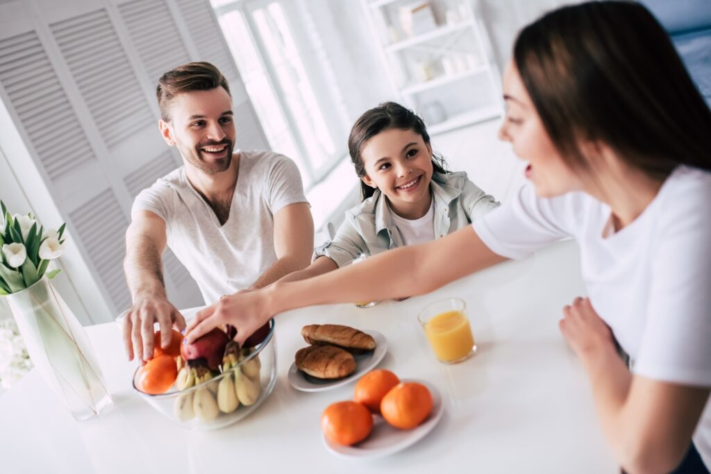 The happy family taking an apples on the table