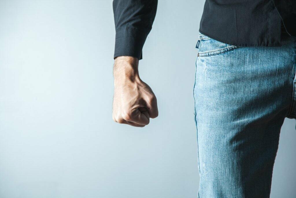 angry man fist on gray wall background