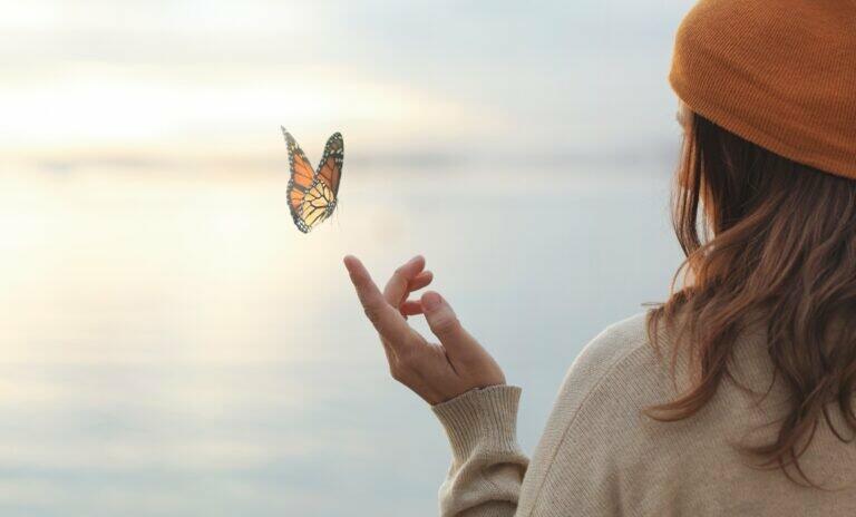 colorful butterfly is laying on a woman's hand
